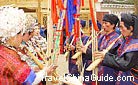 Miao people, dressed in festival costumes, were playing Lusheng (a reed-pipe wind instrument) on Flying Cloud Cliff, Guizhou.