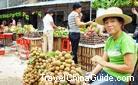 A pedlar with satisfied smile seems to show us the choice longans in front of her.