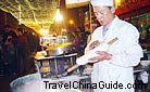 In the night market, the chef is making Shaved Noodles for sale.