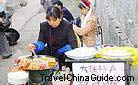 The woman is making local snack for sale.