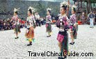 Beautiful Miao girls in their traditional costumes dancing for tourists, Langde Miao Village, Guizhou.