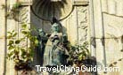 A lovely pigeon sits on the head of a statue embedded in the Ruins of St. Paul's Church in Macau.