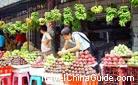 Here is a fruit market that abundant fruits are on sale. Bananas hanging over the head, Pitayas and other fruits are sure to attract you to stop and buy some.